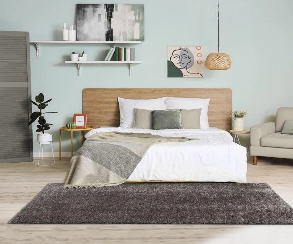 Cozy bedroom features a soft dark gray shag area rug.