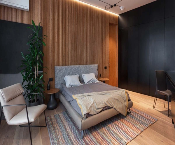 Modern bedroom with textured wood wall light bed striped rug.