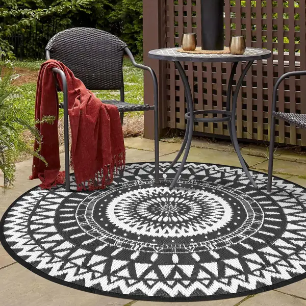 Black and white round rug, Dubai patio, metal table, wicker chairs.