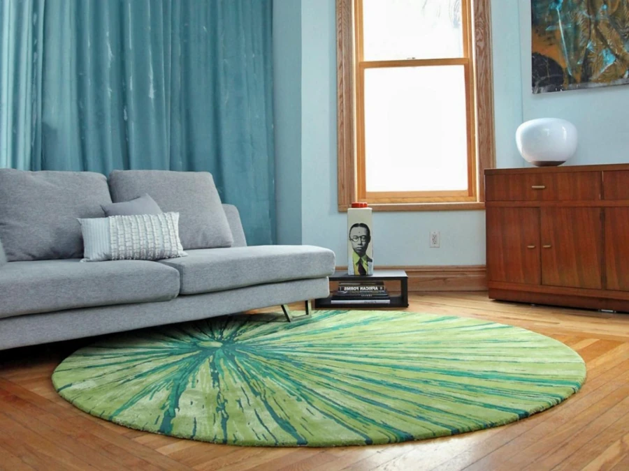 Round green sunburst rug in living room.